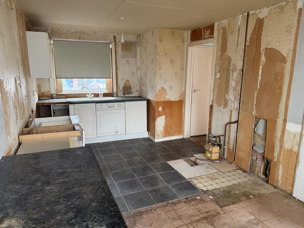 Lot: 107 - THREE-BEDROOM HOUSE IN NEED OF COMPLETE REFURBISHMENT - Kitchen with units removed and front window
